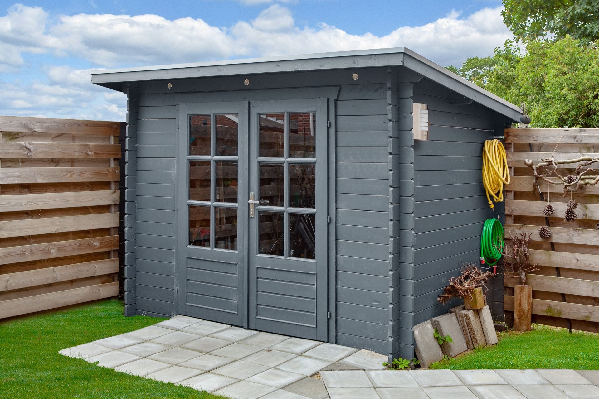 Deze compacte houten blokhut met lessenaarsdak is ideaal voor wie een nette en functionele opberg- of werkruimte in de tuin zoekt. Het geschaafde en gedroogde vurenhout biedt een strakke afwerking, terwijl de vaste roedes en dubbele deuren met enkel glas voor lichtinval en een uitnodigende uitstraling zorgen. Dankzij het slimme formaat past deze blokhut zelfs in kleinere tuinen. Kenmerken & Constructie: Afmetingen blokhut: Lengte 290 cm x Breedte 200 cm Wanddikte: 28 mm – solide en duurzaam Nokhoogte: 217 cm Totale oppervlakte: 4,61 m² Inhoud: 9,6 m³ Daktype: Lessenaarsdak (dakbedekking optioneel bij te bestellen) Dakoppervlakte: 6,8 m² Indeling: Binnenruimte: 4,61 m² vloeroppervlak Aantal ruimtes: 1 Materialen & Details: Materiaal: Onbehandeld, geschaafd en gedroogd vurenhout Deurtype: Dubbele deur, rechts scharnierend Glas: Enkel glas van 3 mm met vaste roedes Fundering: 270 x 180 cm Afmeting hoekverbinding: 10 cm Cilinderslot inbegrepen Extra eigenschappen: Niet geschikt voor dakpannen Compact en stijlvol – ideaal als berging of werkhoek Een praktische en stijlvolle blokhut voor wie op zoek is naar een efficiënte oplossing met een strakke uitstraling. 👉 Voor een volledige offerte kun je een afspraak maken of langskomen bij Blokhut.nl in Klazienaveen. Deze compacte houten blokhut met lessenaarsdak is ideaal voor wie een nette en functionele opberg- of werkruimte in de tuin zoekt. Het geschaafde en gedroogde vurenhout biedt een strakke afwerking, terwijl de vaste roedes en dubbele deuren met enkel glas voor lichtinval en een uitnodigende uitstraling zorgen. Dankzij het slimme formaat past deze blokhut zelfs in kleinere tuinen. Kenmerken & Constructie: Afmetingen blokhut: Lengte 290 cm x Breedte 200 cm Wanddikte: 28 mm – solide en duurzaam Nokhoogte: 217 cm Totale oppervlakte: 4,61 m² Inhoud: 9,6 m³ Daktype: Lessenaarsdak (dakbedekking optioneel bij te bestellen) Dakoppervlakte: 6,8 m² Indeling: Binnenruimte: 4,61 m² vloeroppervlak Aantal ruimtes: 1 Materialen & Details: Materiaal: Onbehandeld, geschaafd en gedroogd vurenhout Deurtype: Dubbele deur, rechts scharnierend Glas: Enkel glas van 3 mm met vaste roedes Fundering: 270 x 180 cm Afmeting hoekverbinding: 10 cm Cilinderslot inbegrepen Extra eigenschappen: Niet geschikt voor dakpannen Compact en stijlvol – ideaal als berging of werkhoek Een praktische en stijlvolle blokhut voor wie op zoek is naar een efficiënte oplossing met een strakke uitstraling. 👉 Voor een volledige offerte kun je een afspraak maken of langskomen bij Blokhut.nl in Klazienaveen.
